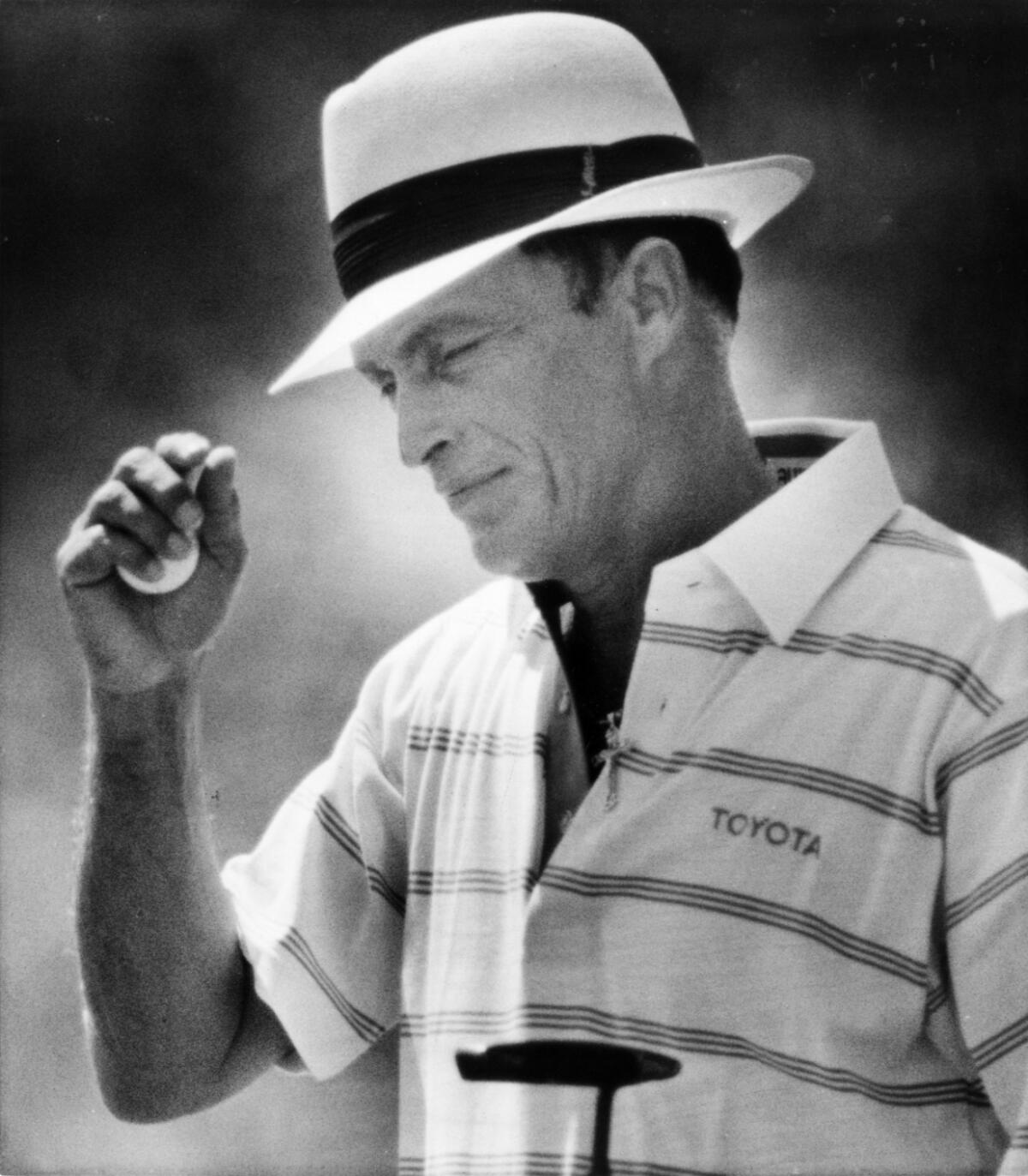 Chi Chi Rodriguez tips his hat to the gallery after sinking a putt for par during a senior tournament in 1987 