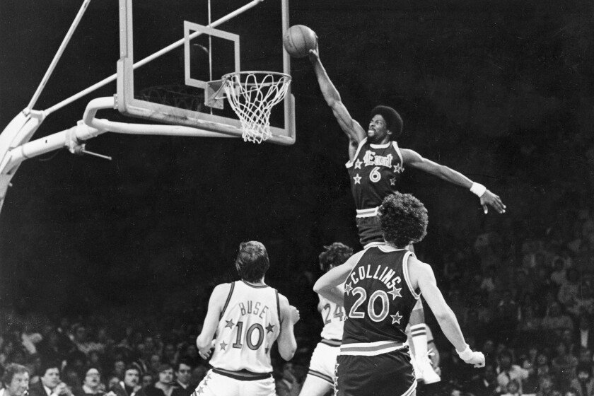 FILE - Sixers' Julius Erving (6) dunks the ball through the basket over Chicago Bulls' Artis Gilmore (24) during first half of game in Philadelphia, Pa., Jan. 3, 1979. (AP Photo, File)