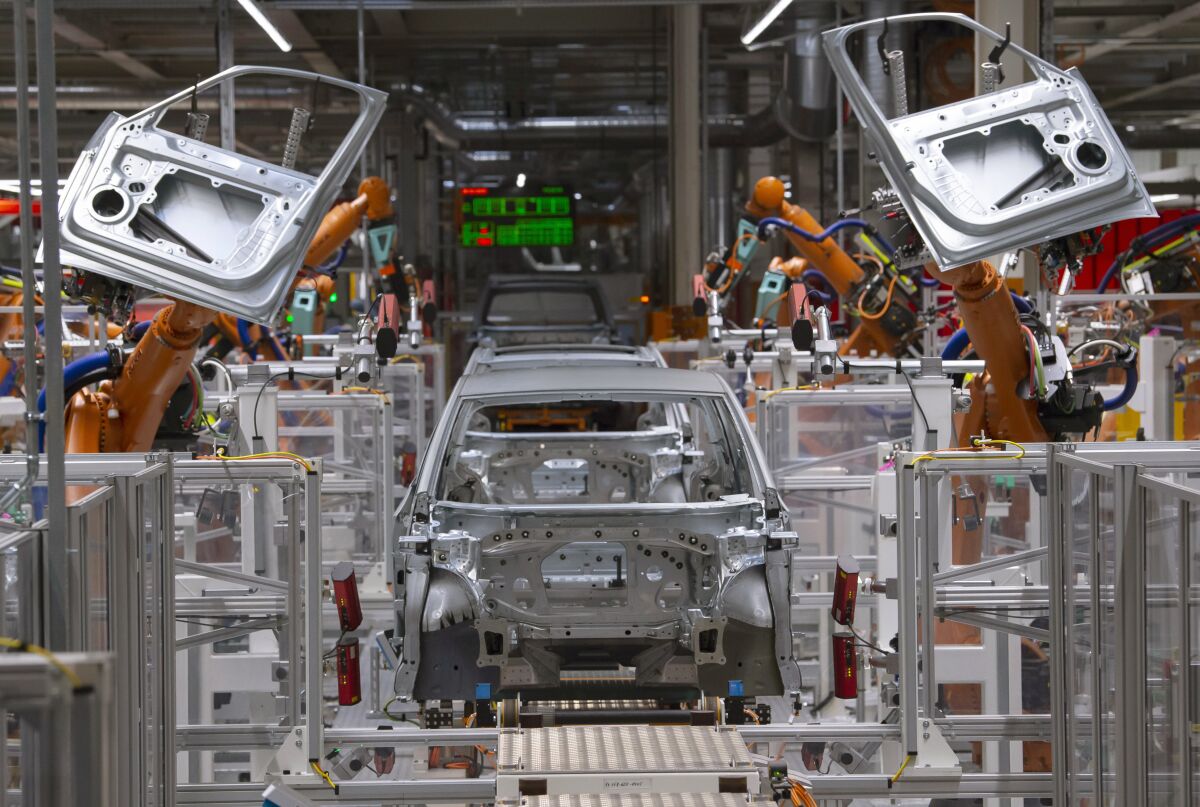 Robots work on an electric car ID.3 body at a Volkswagen plant in Zwickau, Germany.