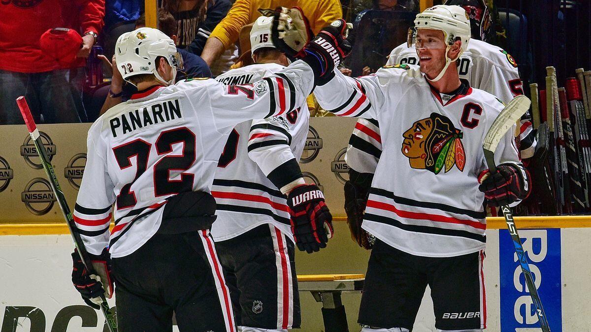 The Chicago Blackhawks' Jonathan Toews, right, high-fives teammate Artemi Panarin after a 5-3 victory over the Nashville Predators on Saturday.