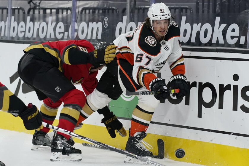Anaheim Ducks center Rickard Rakell passes around Vegas Golden Knights defenseman Zach Whitecloud.