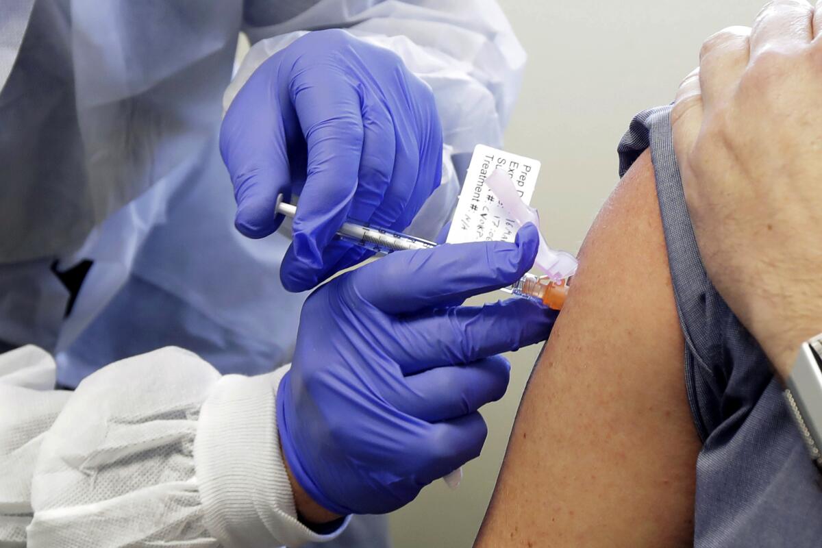 A test subject receives a dose of a vaccine against COVID-19 produced by Moderna Inc.