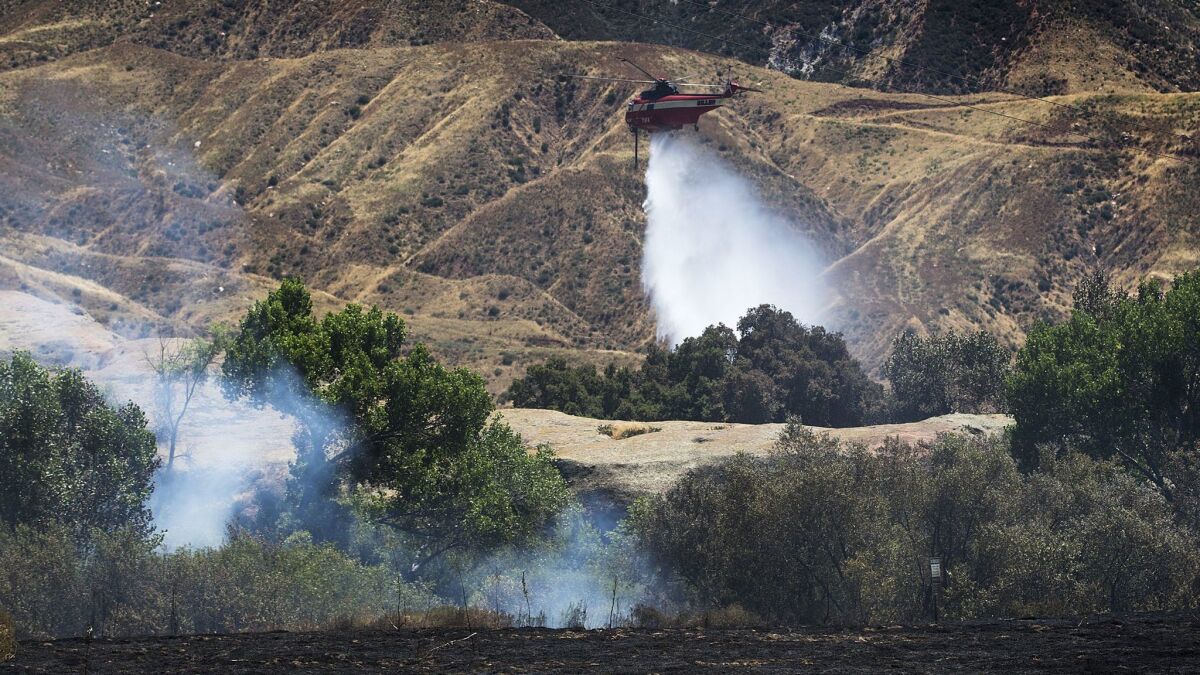 A water dropping helicopter drops its load to stop the advance of the Manzanita fire.