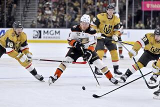 Anaheim Ducks center Trevor Zegras (11) skates with the puck between Vegas Golden Knights.