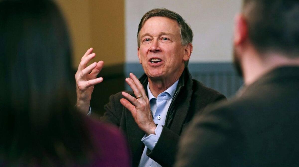 Former Democratic Colorado Gov. John Hickenlooper meets with AmeriCorps members at a roundtable campaign stop in Manchester, N.H., on Friday.