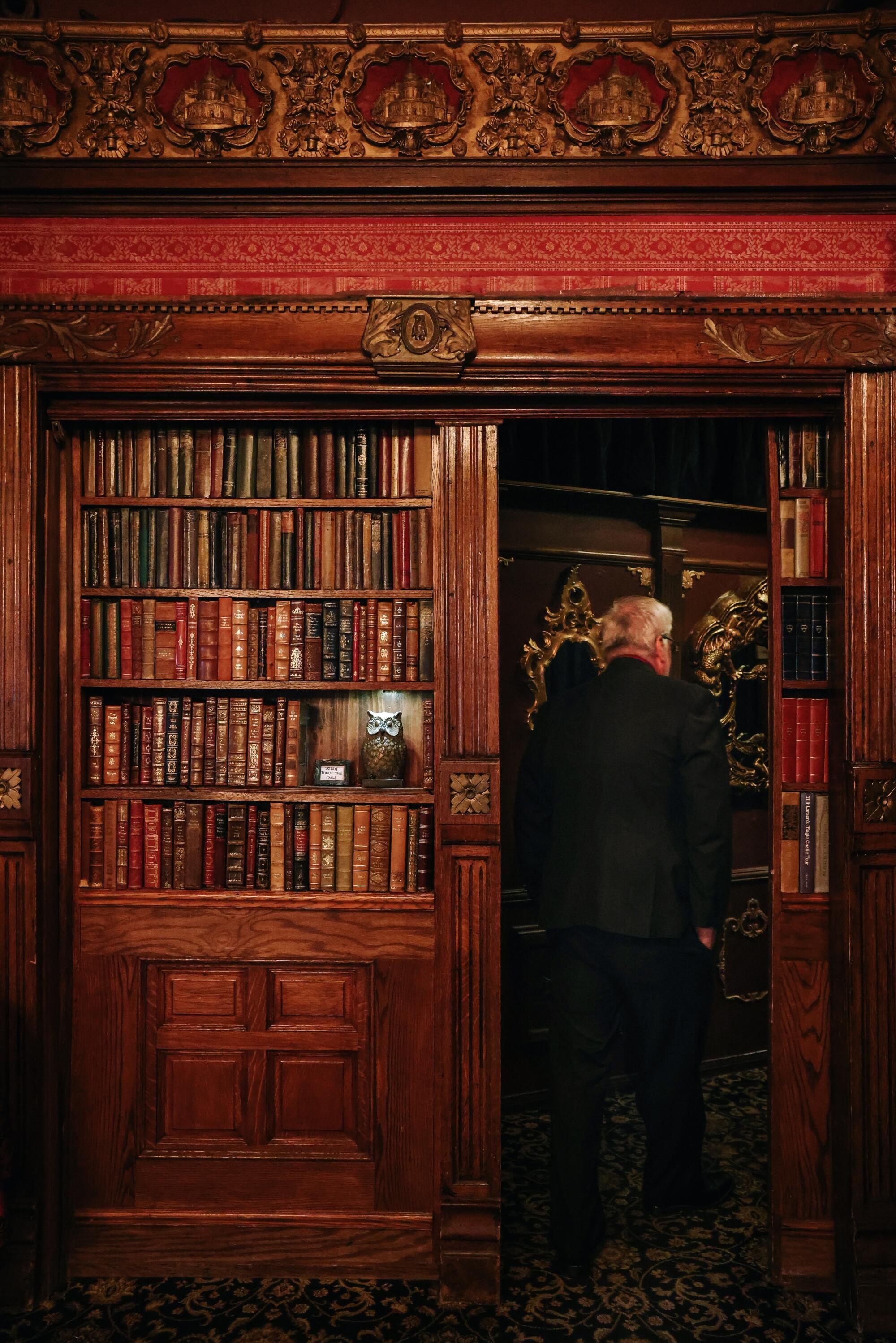 A guest disappears behind a faux bookshelf.