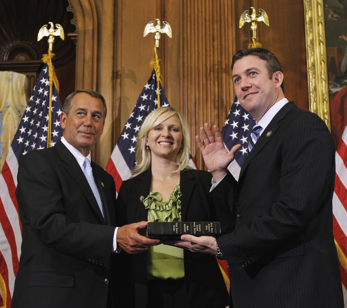 FILE - In this Jan. 5, 2011, file photo, then House Speaker John Boehner of Ohio, left, administers the House oath to Rep. Duncan Hunter, R-Calif., as his wife, Margaret Hunter, looks on during a mock swearing-in ceremony on Capitol Hill in Washington. Margaret Hunter has filed for divorce from former Rep. Duncan Hunter on Nov. 20, 2020, in San Diego Superior Court according to online records. Both were convicted of corruption and prosecutors had said that the lawmaker had used campaign funds on extramarital affairs. (AP Photo/Alex Brandon, File)
