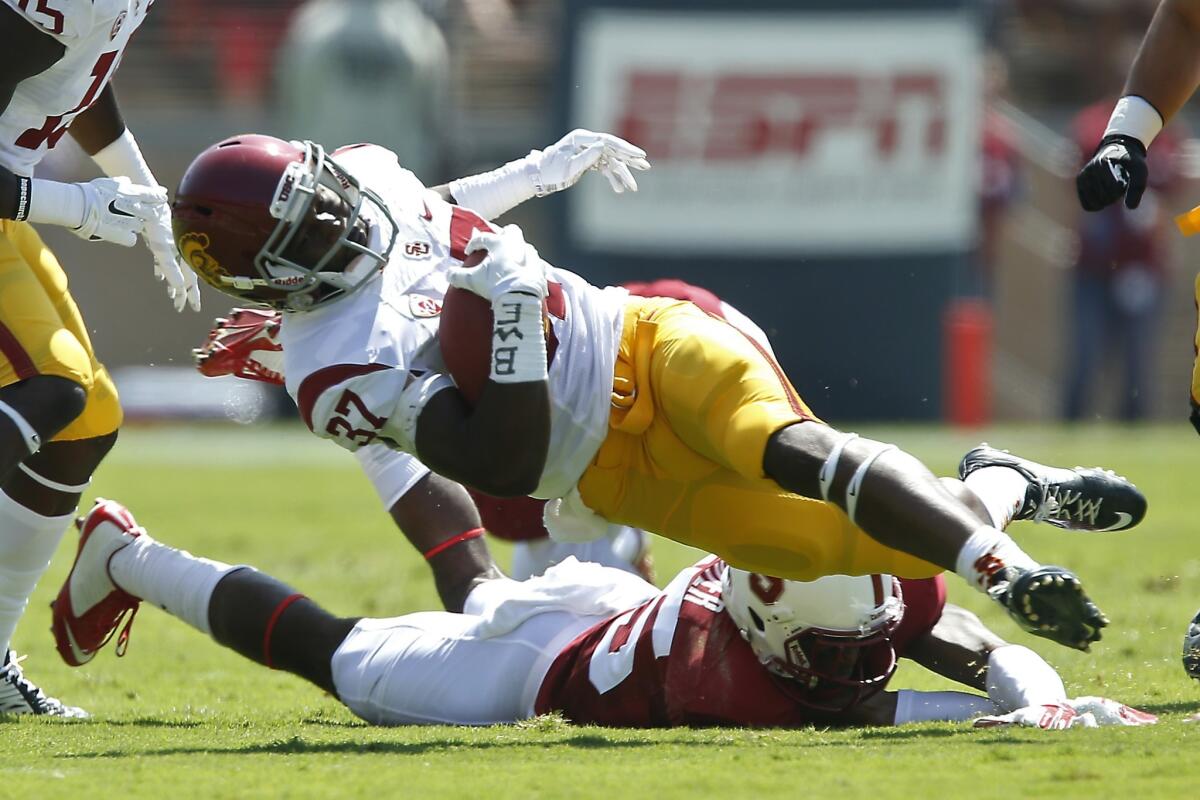 USC running back Javorius Allen is tripped up by Stanford cornerback Alex Carter during the first half of Saturday's game.