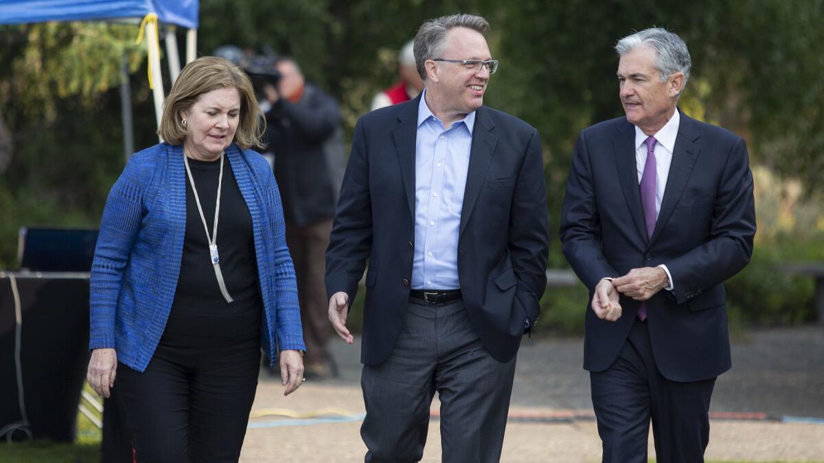From left, Esther George, president of the Federal Reserve Bank of Kansas City, John Williams, president of the Federal Reserve Bank of New York, and Jerome H. Powell, chairman of the Federal Reserve, walk together at a central bankers conference in Wyoming on Friday.