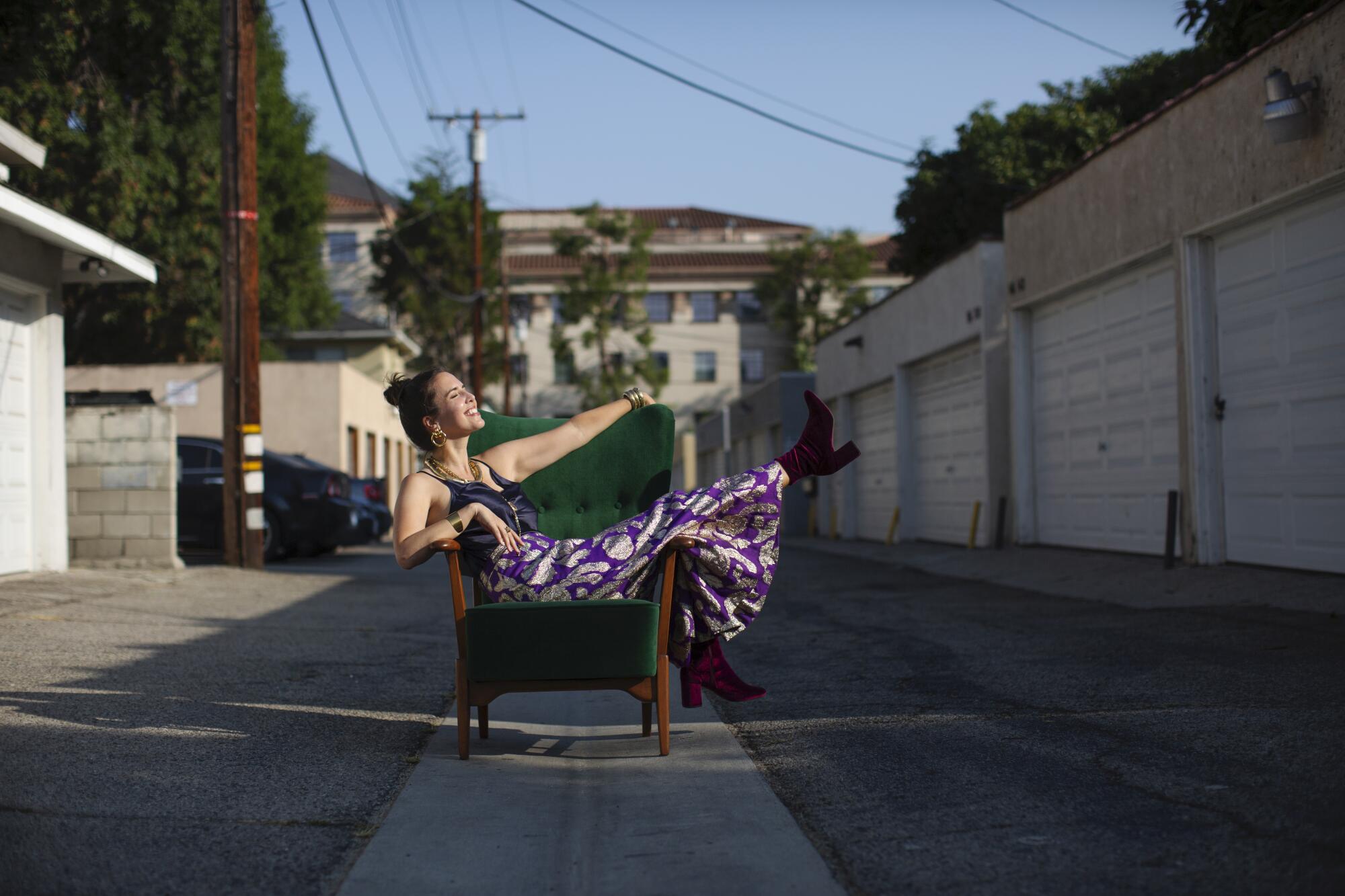 Analise McNeill poses in an alley on a green chair.