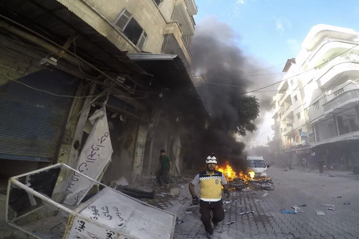 A Syrian White Helmet civil defense worker runs at the site where a shell struckhite Helmets via AP)