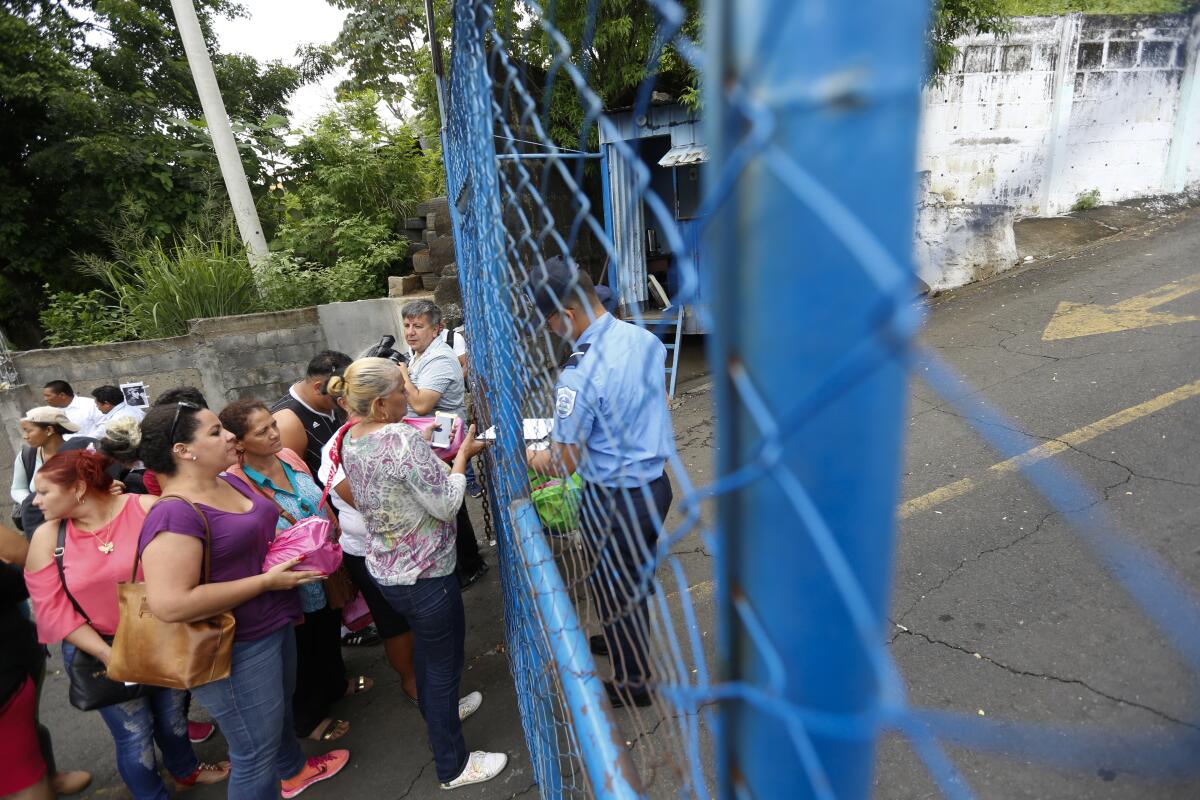 People outside a fence with an officer on the inside