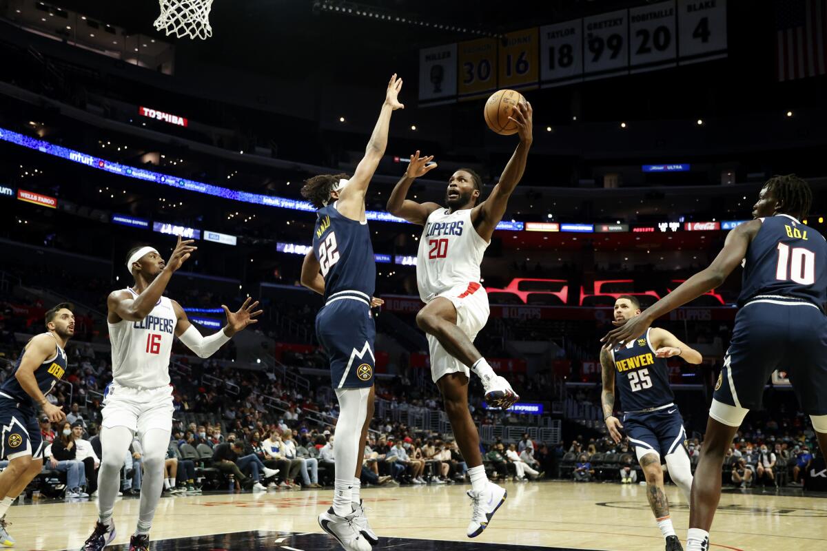Clippers forward Justise Winslow drives to basket against Denver Nuggets forward Zeke Nnaji.
