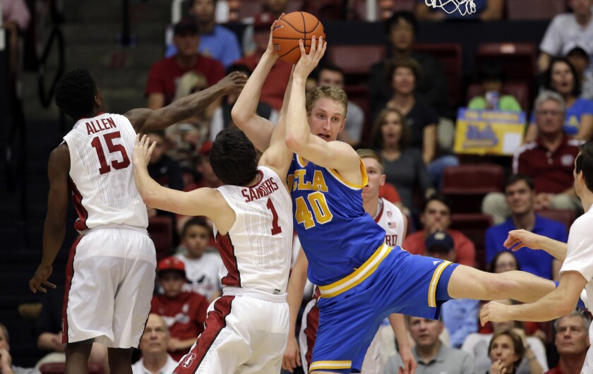 UCLA center Thomas Welsh (40) grabs a rebound next to Stanford guard Christian Sanders (1) and guard Marcus Allen (15) during the second half of a game on Feb. 27.