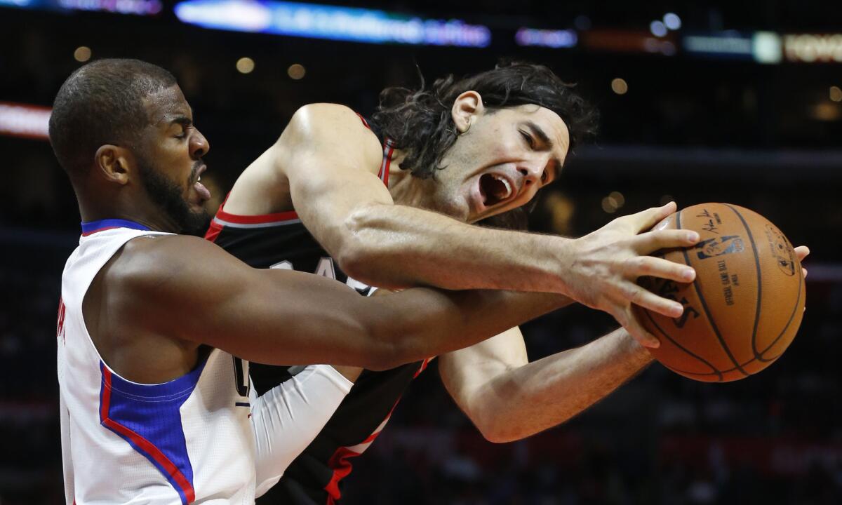 Toronto forward Luis Scola controls the ball despite the efforts of Clippers guard Chris Paul, left, in a game Nov. 22.