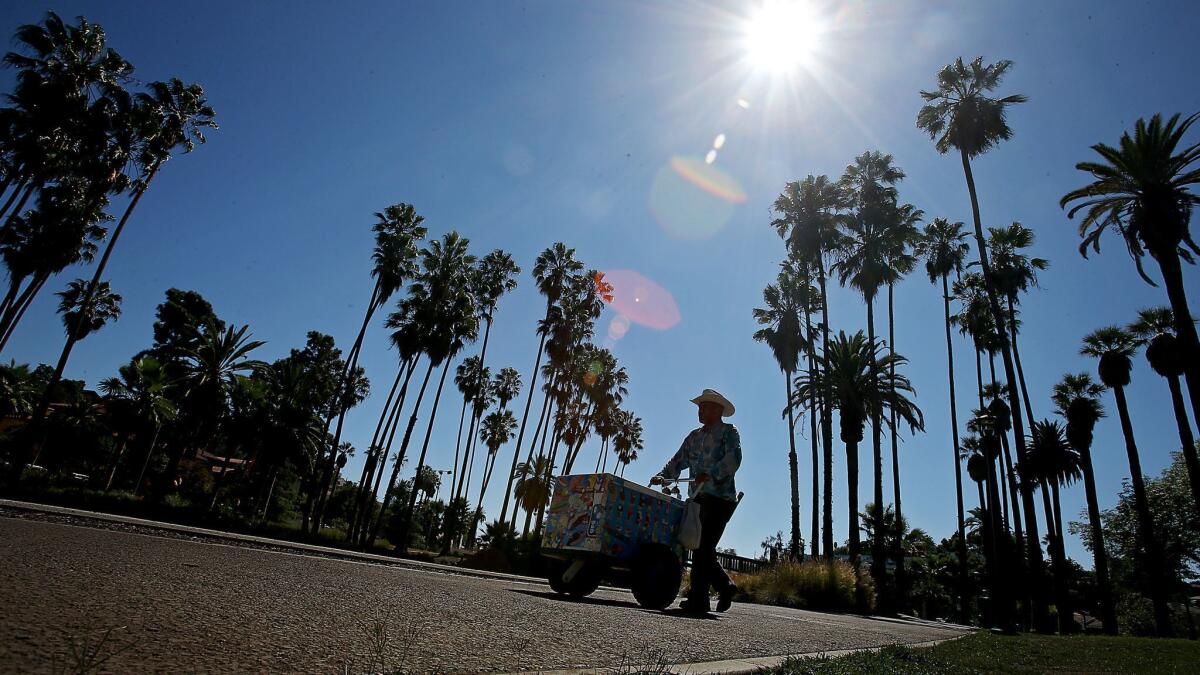 An ice cream vendor pushes a cart in Echo Park in Los Angeles. The Newport Beach City Council tentatively agreed Tuesday to allow sidewalk vendors to sell food and other goods, subject to permitting requirements and many restrictions.