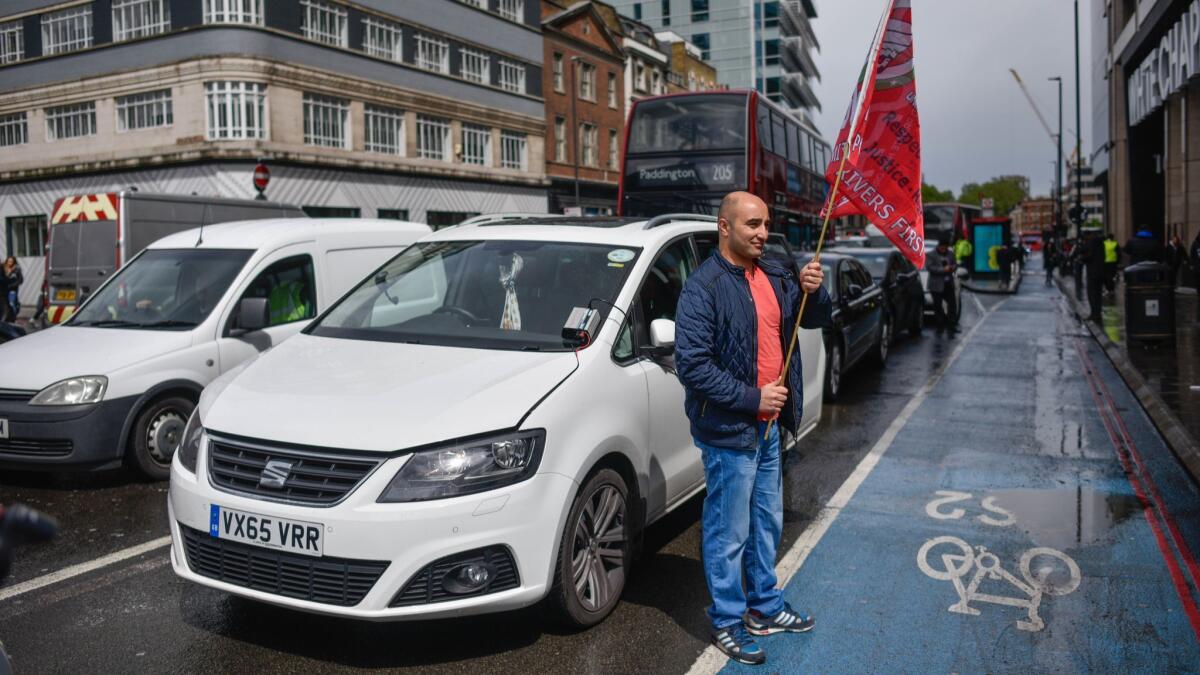 Uber drivers protest outside Uber offices on May 8, 2019, in London.