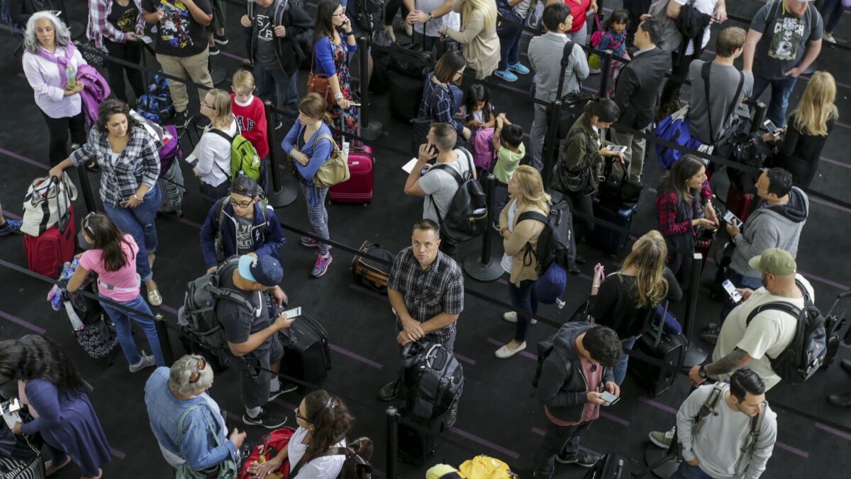 Memorial Day weekend travelers at Los Angeles International Airport stand in a security line on May 26, 2017. Airlines and the Transportation Security Administration predict a record number of air travelers this summer.