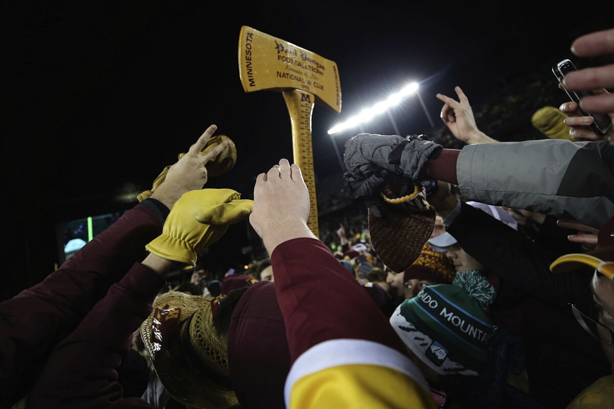 Minnesota fans reach up toward Paul Bunyan's Axe after the Gophers defeated Wisconsin.