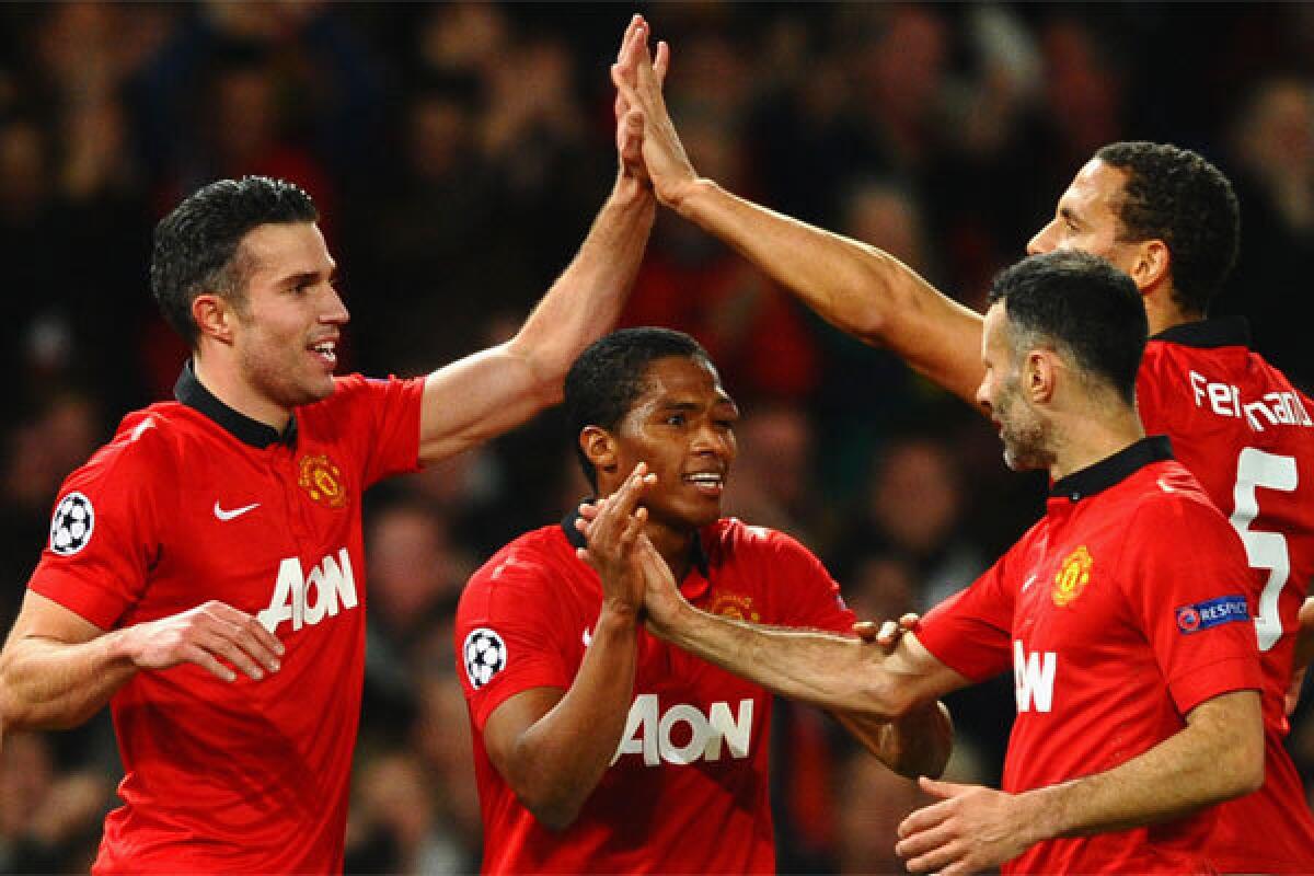Manchester United's Robin van Persie celebrates with his teammates after scoring the second goal against Olympiacos at Old Trafford on March 19.