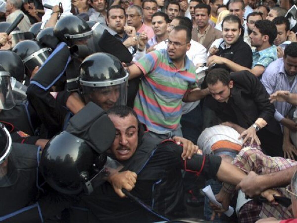 Egyptian activists struggle with anti-riot soldiers during a protest in Cairo, Egypt, Tuesday, Sept.21, 2010. Egyptian police beat and arrested anti-government activists demonstrating outside the downtown presidential palace against a possible father-son succession in the country. (AP Photo/Ahmed Ali)