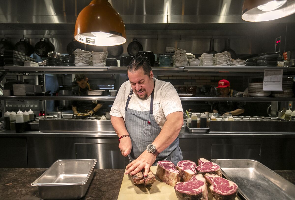 Chef Amar Santana cuts a 55-day dry-aged ribeye on at Vaca in Costa Mesa.