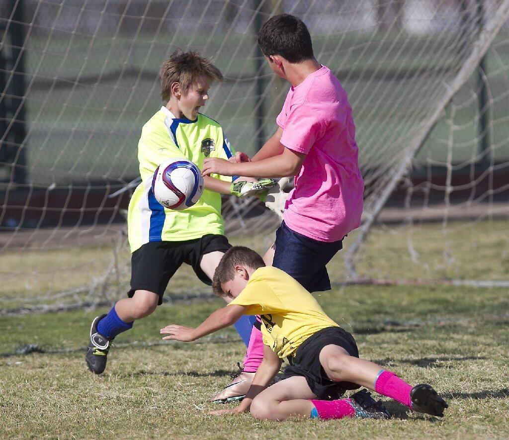 Carden Hall goalie Garrett Richards jumps in to stop a point-blank shot by St. Joachim's Ben Chiano, in pink, in the boys' 5-6 Silver Division game of the Pilot Cup on Thursday.