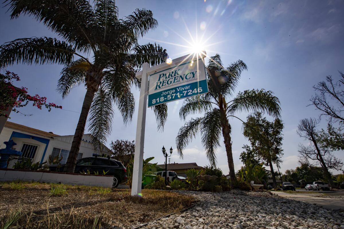 A real estate agency's sign is in front of a home for sale in the Mission Hills area of Los Angeles 