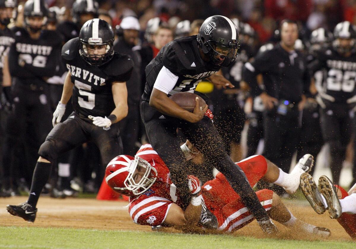 Anaheim Servite quarterback Travis Waller is stopped by Julio Hernandez of Mater Dei during a football game on Oct. 11.