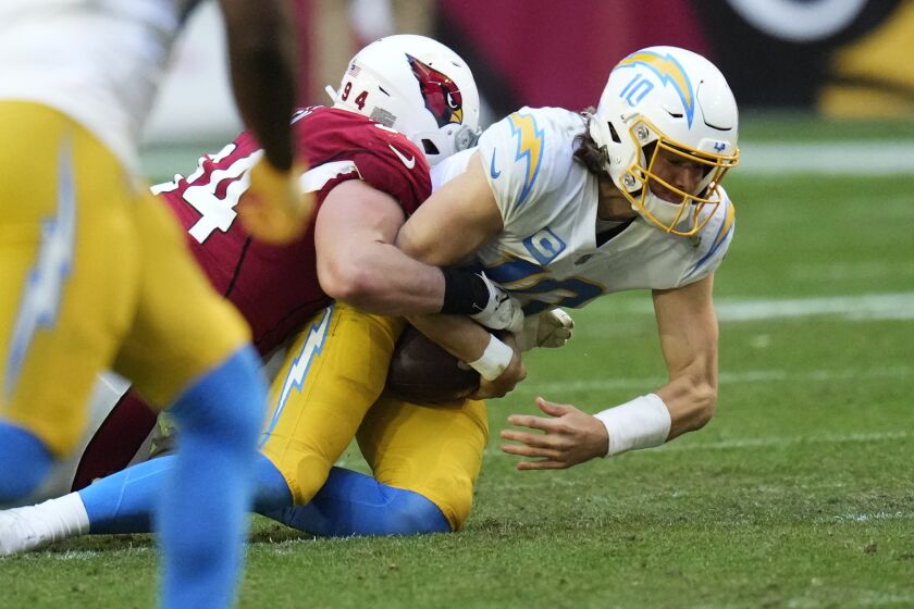 Arizona Cardinals defensive end Zach Allen (94) sacks Los Angeles Chargers quarterback Justin Herbert (10) during the second half of an NFL football game, Sunday, Nov. 27, 2022, in Glendale, Ariz. The Chargers defeated the Cardinals 25-24. (AP Photo/Ross D. Franklin)
