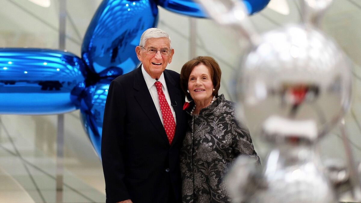 Billionaire and charter supporter Eli Broad and his wife, Edythe, stand for a photo amid Jeff Koons sculptures at his new museum called "The Broad" in downtown Los Angeles.