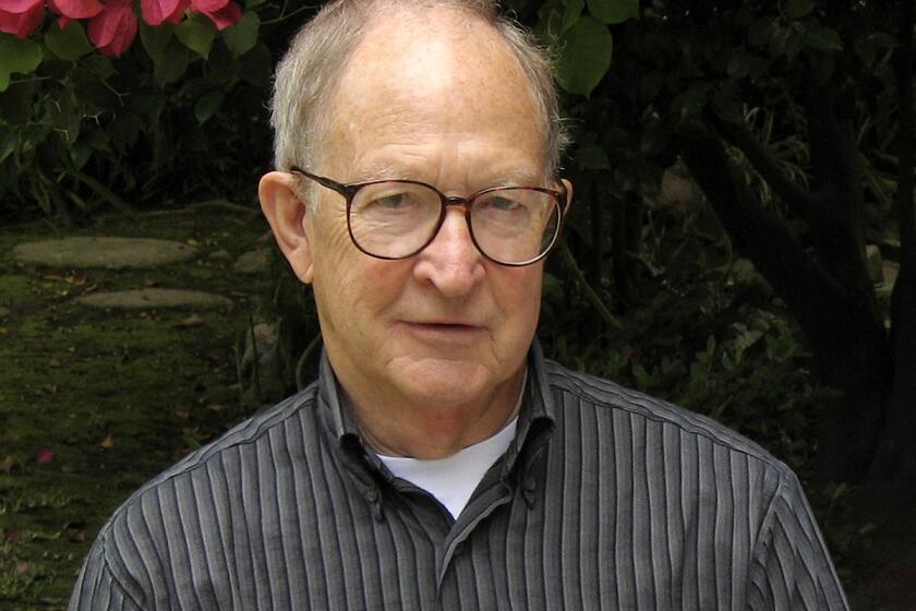 A man wearing glasses is pictured sitting on a bench.