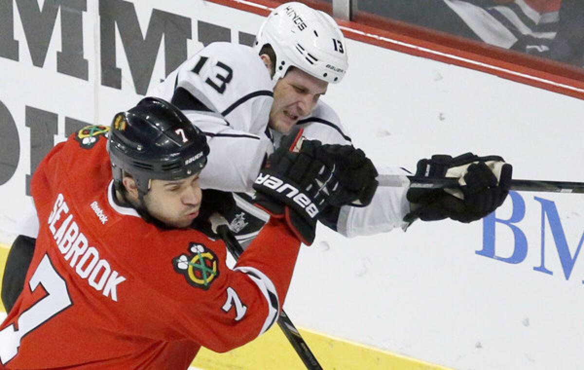Chicago Blackhawks defenseman Brent Seabrook, bottom, battles Kings left wing Kyle Clifford during the Kings' 1-0 loss on Dec. 30. The Kings hope to break out of their slump with a win over the defending Stanley Cup champions Monday.