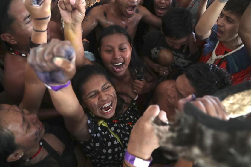 Indigenous people celebrate a Supreme Court ruling to enshrine Indigenous land rights, in Brasilia, Brazil, Thursday, Sept. 21, 2023. Six of the 11 Supreme Court justices voted against establishing a cut-off date after which Indigenous peoples could not claim new territory. (AP Photo/Gustavo Moreno)