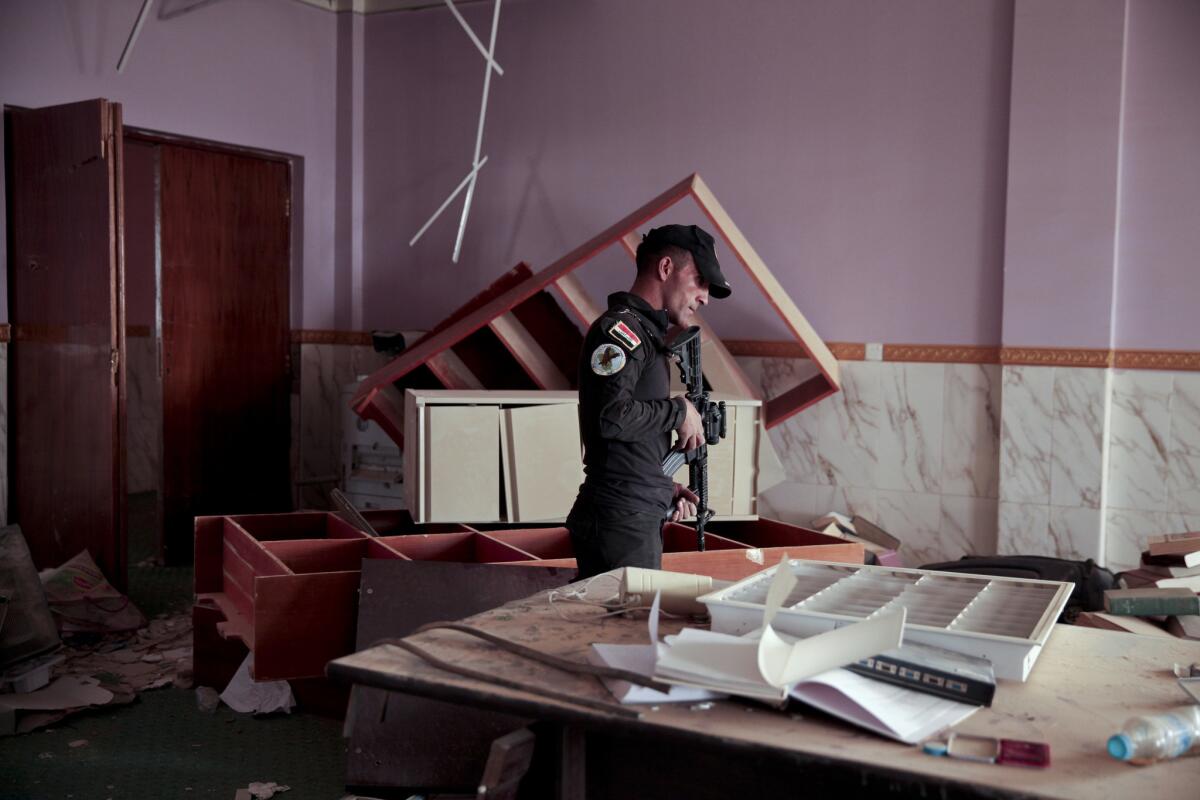 A member of Iraq's elite counter-terrorism forces walks through the library of the University of Anbar in the city of Ramadi on March 20, 2016.