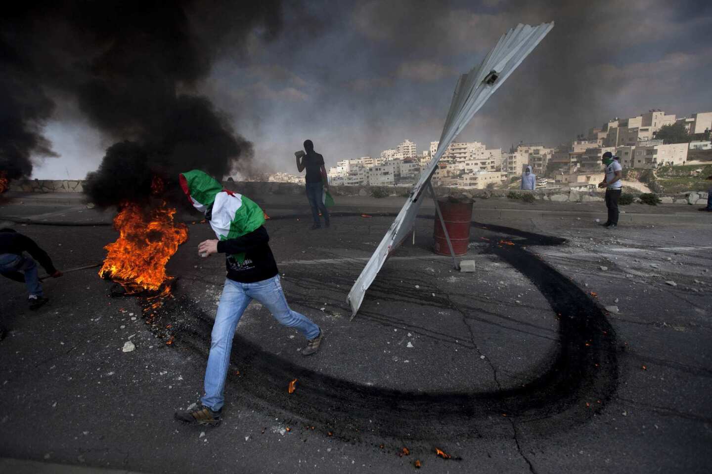 Masked Palestinians clash with Israeli forces during a Land Day demonstration in East Jerusalem.