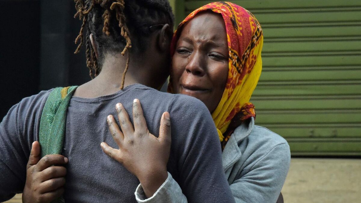 A woman cries in the arms of a relative in Nairobi on Jan. 16 while identifying the bodies of the victims after an attack on a hotel complex.