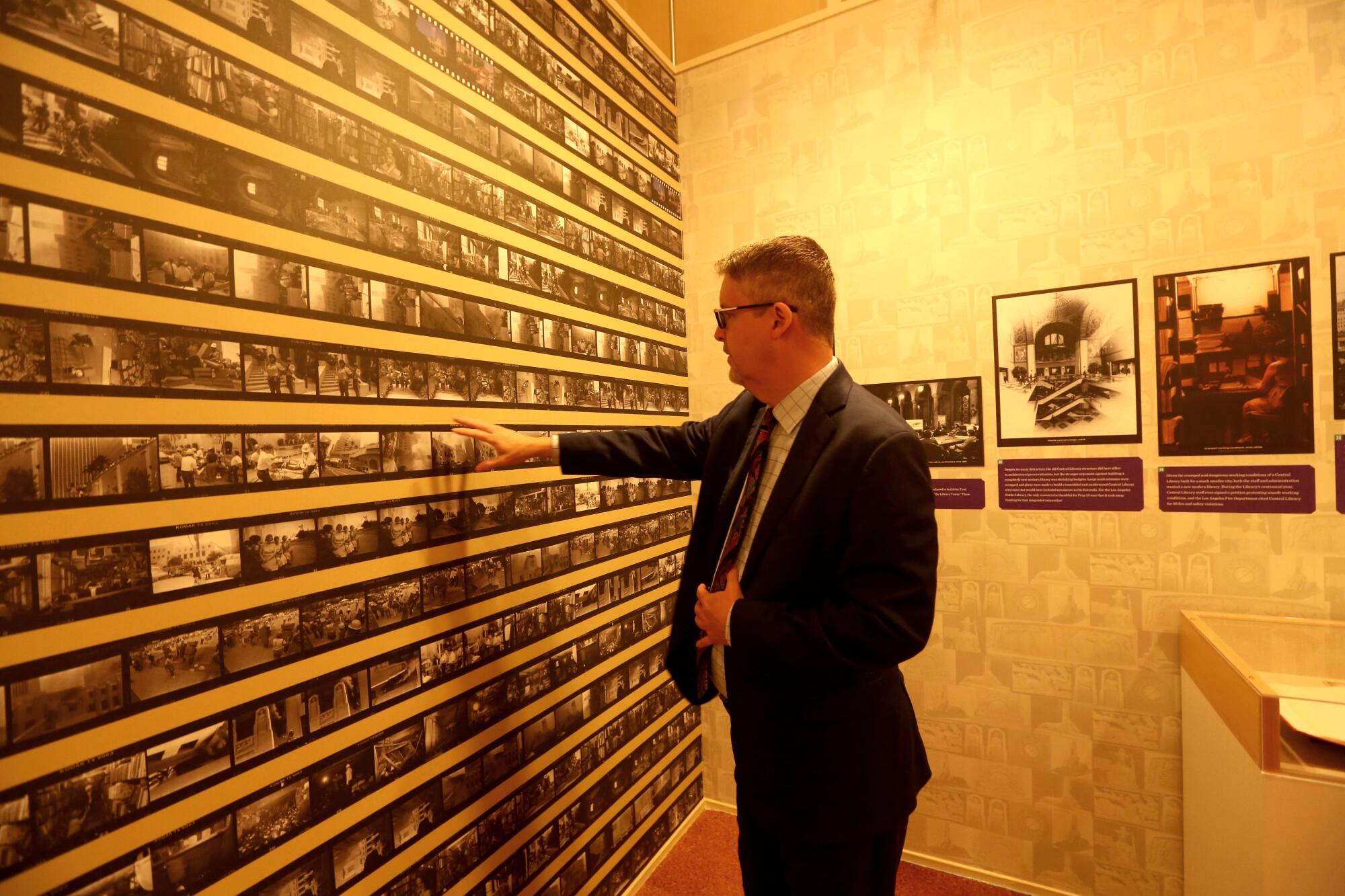 City Librarian John Szabo looks over a contact sheet of photographs created of the fire that struck the library in 1986. 