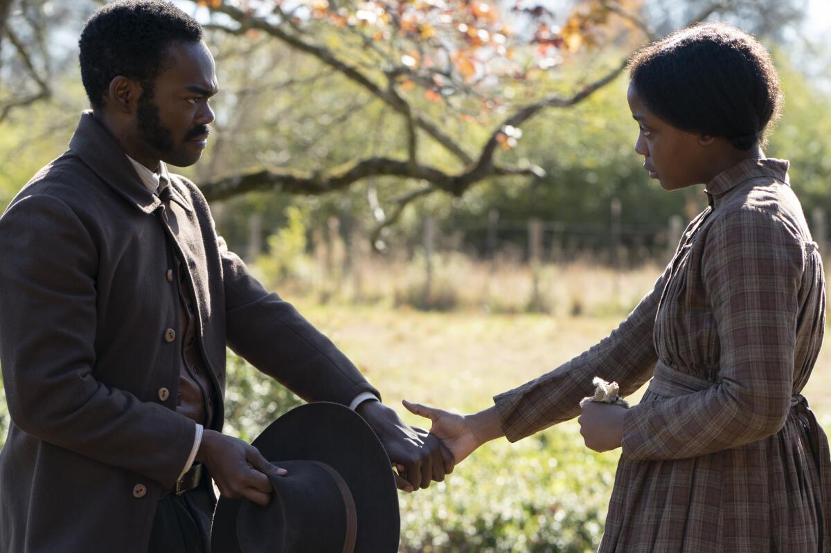 William Jackson Harper and Thuso Mbedu hold hands in a scene in "The Underground Railroad."