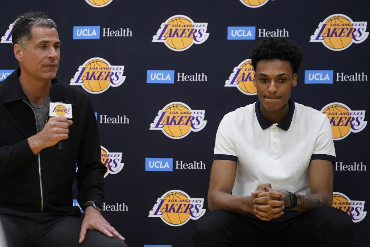 Lakers GM Rob Pelinka, left, addresses the media after introducing the team's two draft picks, including Maxwell Lewis, right