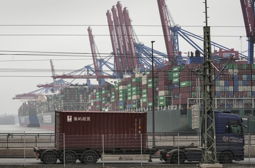 FILE - A truck drives in front of huge container ships at the port in Hamburg, Germany, Wednesday, Jan. 19, 2022. The harbor in Hamburg is Germany's largest seaport and the gateway for the country's export and import economy. Europe's biggest economy, has picked up unexpectedly after a six-month slide, a closely watched survey showed Tuesday. (AP Photo/Martin Meissner,file)