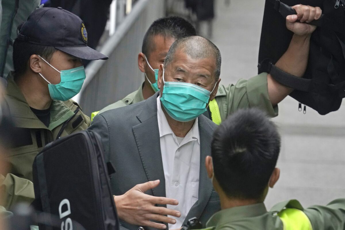 FILE - Democracy advocate Jimmy Lai, center, leaves the Hong Kong's Court of Final Appeal in Hong Kong on Feb. 9, 2021. Lai was sentenced to five years and nine months in prison over two fraud charges linked to lease violations in Hong Kong on Saturday, Dec. 10, 2022 the latest of a series of cases against prominent activists that critics say are aimed at snuffing out dissidents in the city. (AP Photo/Kin Cheung, File)