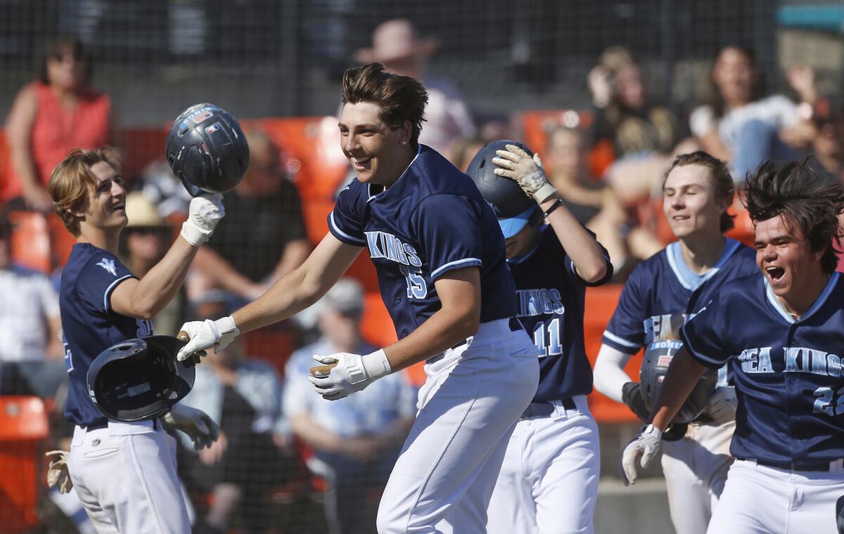 Corona del Mar's Nick Salmon (15) is met at home plate by teammates after slugging a grand slam during Thursday's game.
