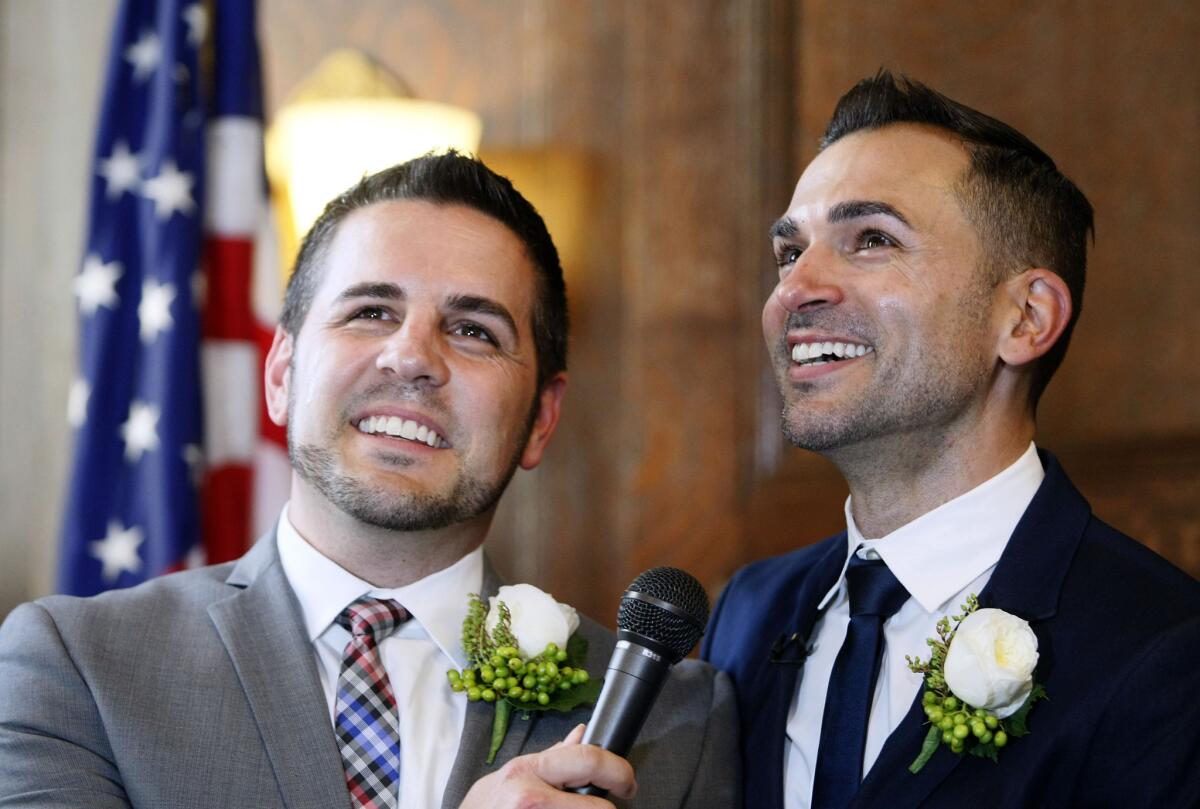 Jeff Zarillo, left, and his partner Paul Katami, right, speak to the media after wedding ceremony officiated by L.A. mayor Antonio Villaraigosa at City Hall in Los Angeles on Friday, June 28, 2013.