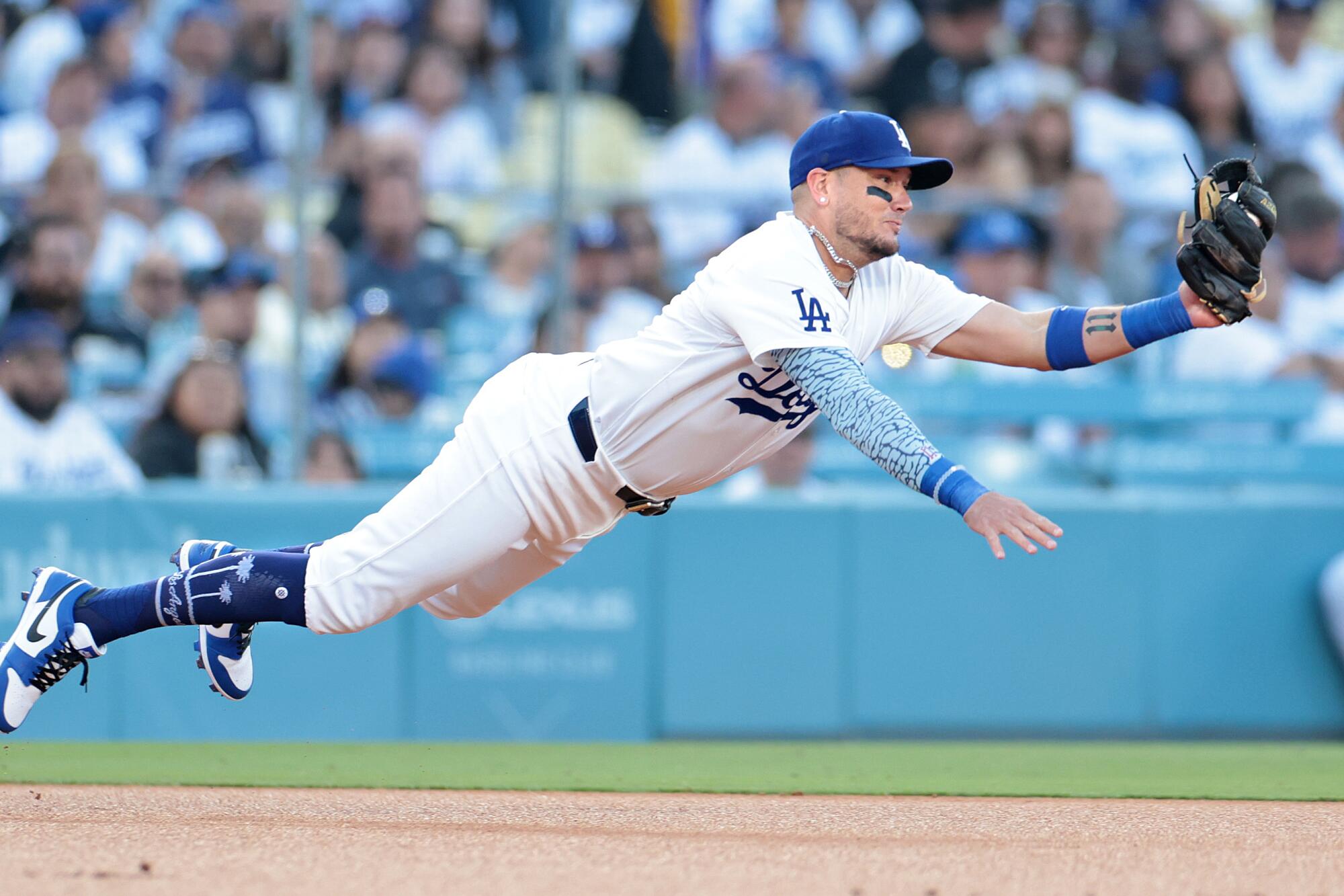 Dodgers shortstop Miguel Rojas makes a diving catch on a liner hit by the Rangers' Marcus Semien at Dodger Stadium.