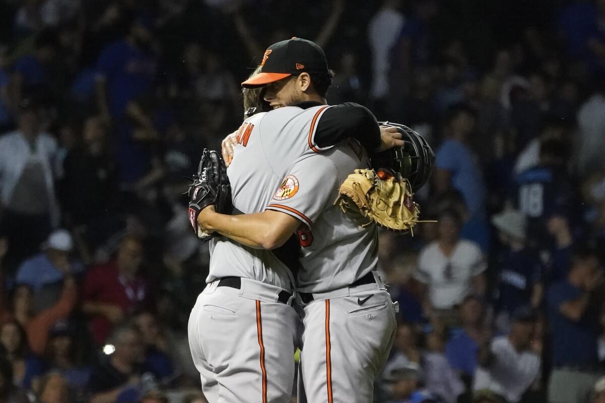Baltimore Orioles relief pitcher Jorge Lopez, right, celebrates with catcher Adley Rutschman the team's 4-2 win over the Chicago Cubs after a baseball game Tuesday, July 12, 2022, in Chicago. The Orioles won their ninth game in a row. (AP Photo/Charles Rex Arbogast)