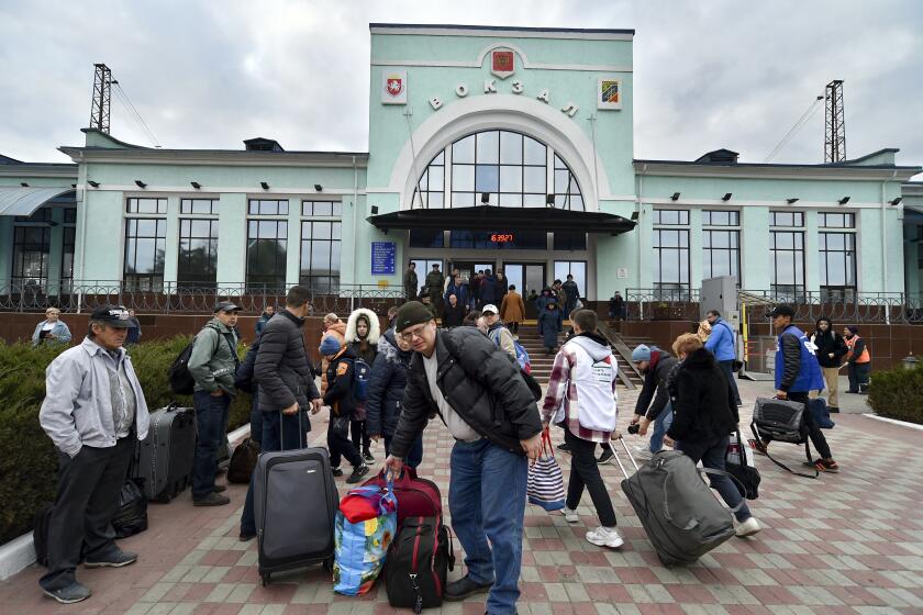Evacuees from Kherson gather upon their arrival at the railway station in Dzhankoi, Crimea, Friday, Oct. 21, 2022. Russian authorities have encouraged residents of Kherson to evacuate, warning that the city may come under massive Ukrainian shelling. (AP Photo)
