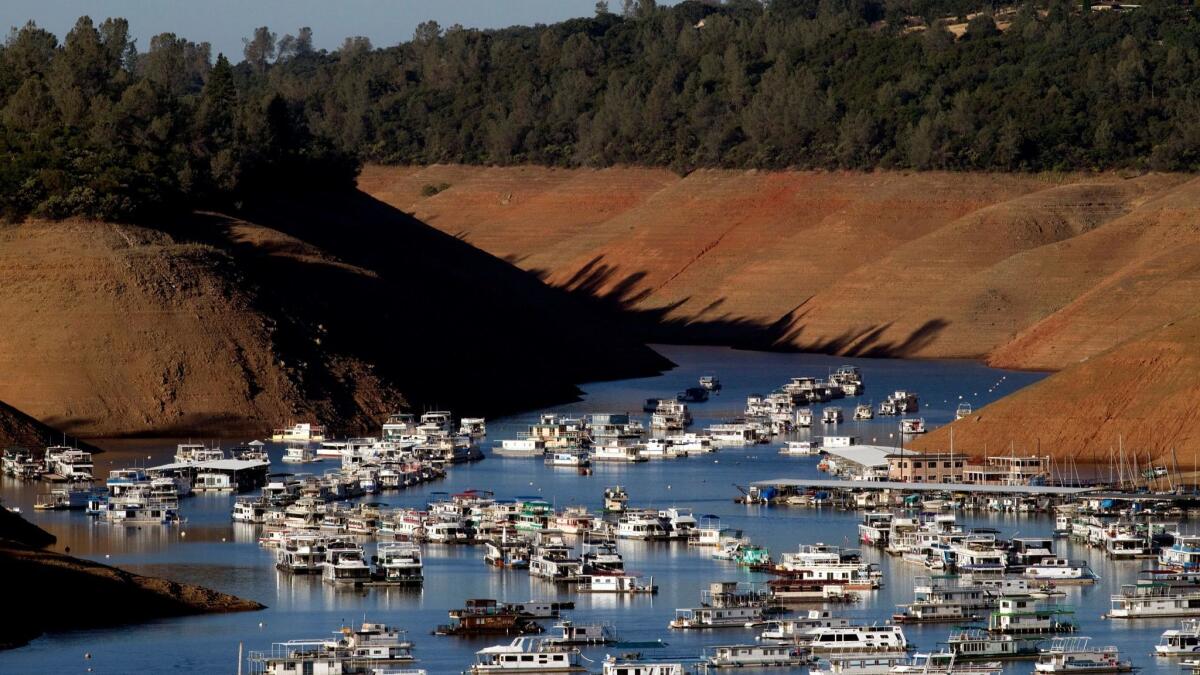 Severe drought conditions are evident as hundreds of houseboats are dwarfed by steep banks showing the water level down 160 feet from the high-water mark at Bidwell Canyon Marina on Lake Oroville on June 21, 2014.