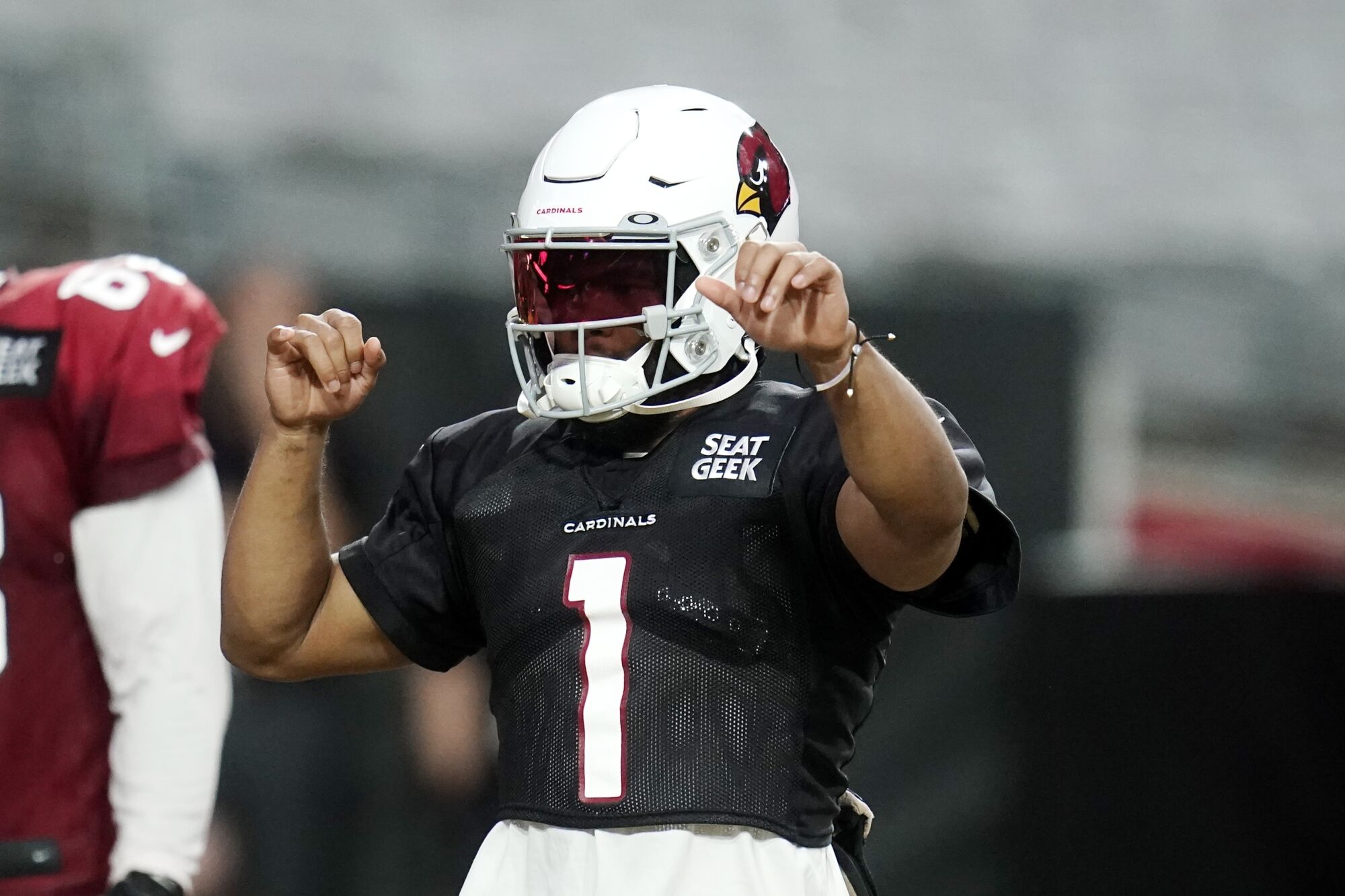 Arizona Cardinals quarterback Kyler Murray signals to receivers while participating in drills.