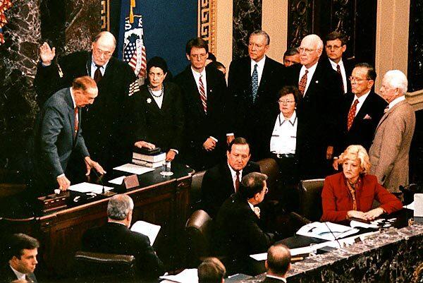As Sen. Byrd, far right, and other members of the Senate look on, Sen. Strom Thurmond swears in Chief Justice William H. Rehnquist to preside over President Clinton's impeachment trial.